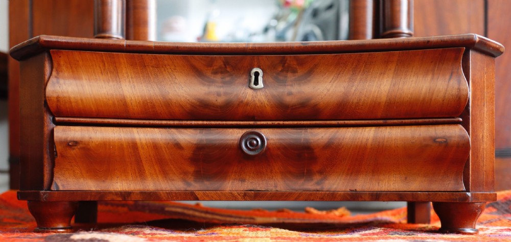 An antique mahogany tabletop toilet mirror featuring an adjustable swivel glass frame supported by turned columns over a two-drawer serpentine base. View IV