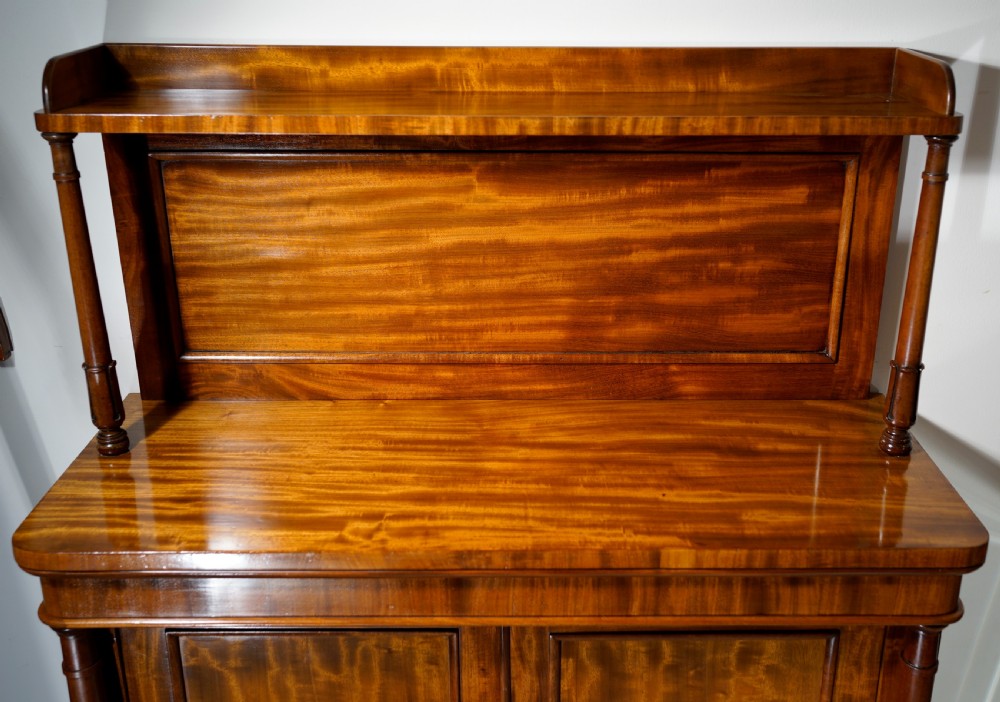 An antique mahogany two-door chiffonier featuring highly figured flame veneer panels, a raised shelf superstructure, and turned column side supports. View III