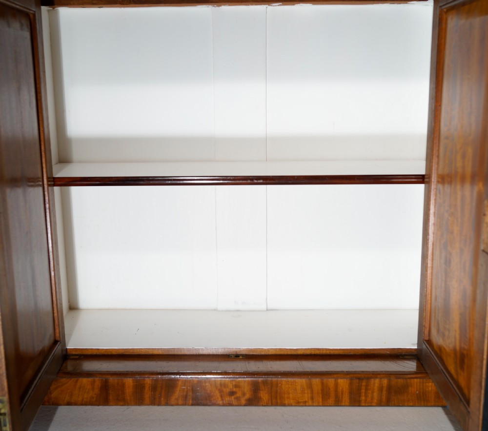 An antique mahogany two-door chiffonier featuring highly figured flame veneer panels, a raised shelf superstructure, and turned column side supports. View V