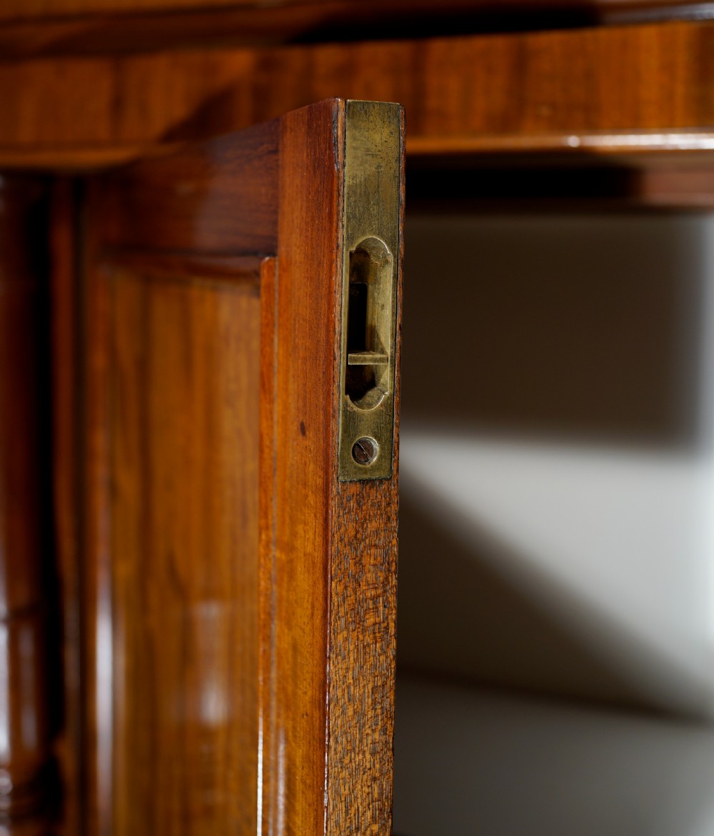 An antique mahogany two-door chiffonier featuring highly figured flame veneer panels, a raised shelf superstructure, and turned column side supports. View VI