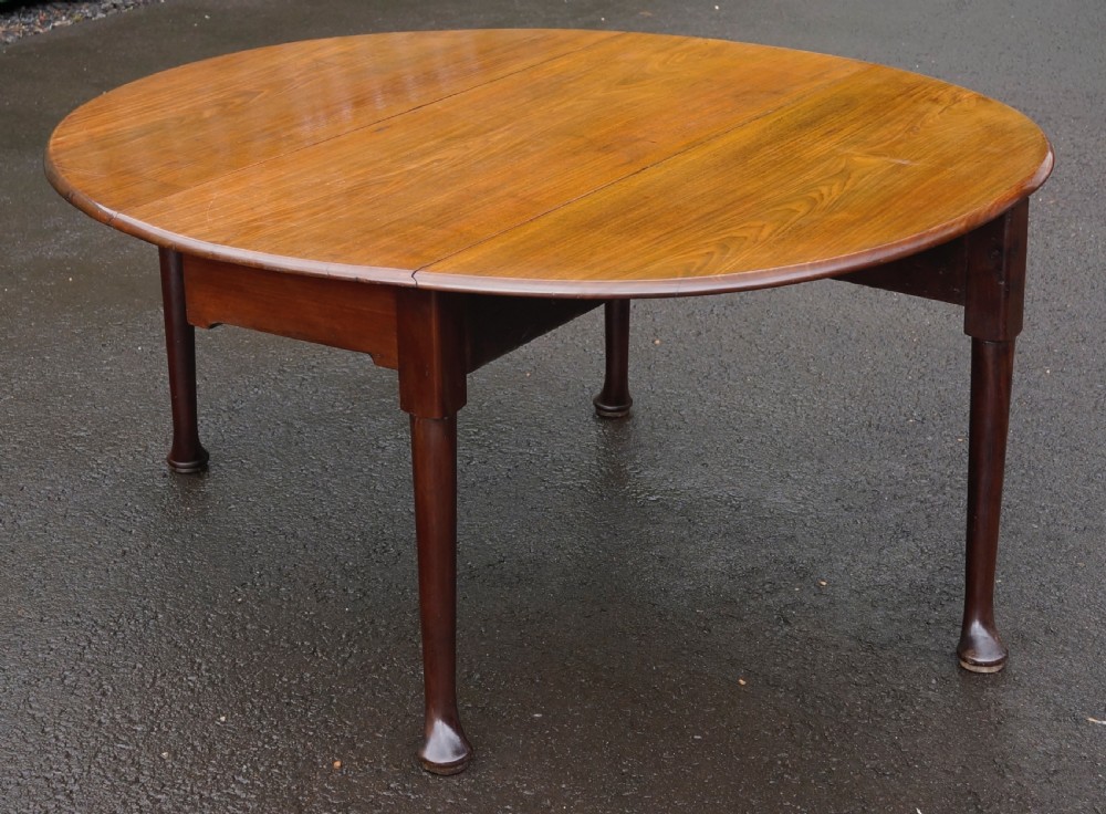 An 18th-century Georgian mahogany oval drop-leaf table resting on turned tapered legs with pad feet. View III