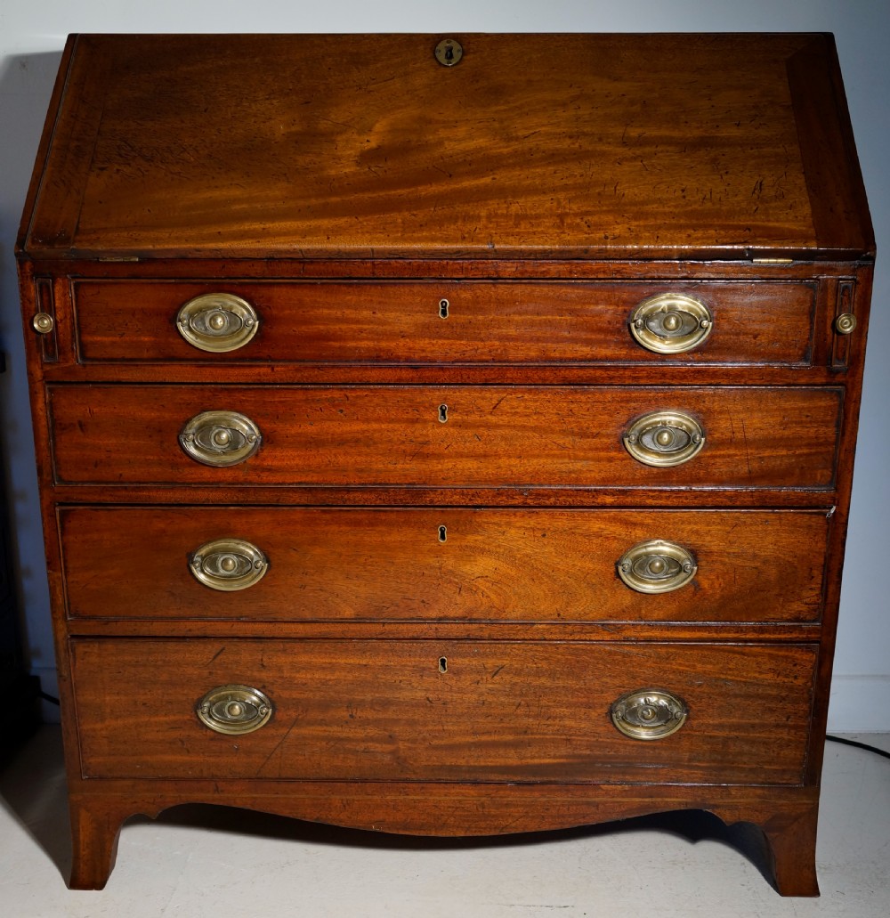 An antique Georgian mahogany bureau featuring a slant-front writing slope over four graduated drawers with brass oval handles. View II