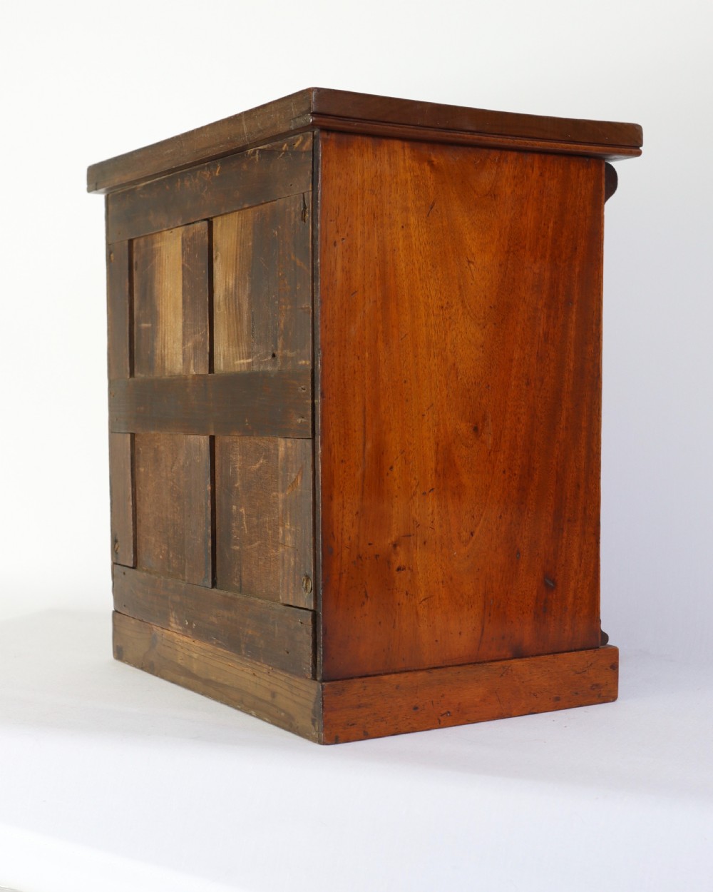A Victorian mahogany miniature chest of drawers featuring two short over three long drawers with turned wooden knobs and side pilasters. View IV