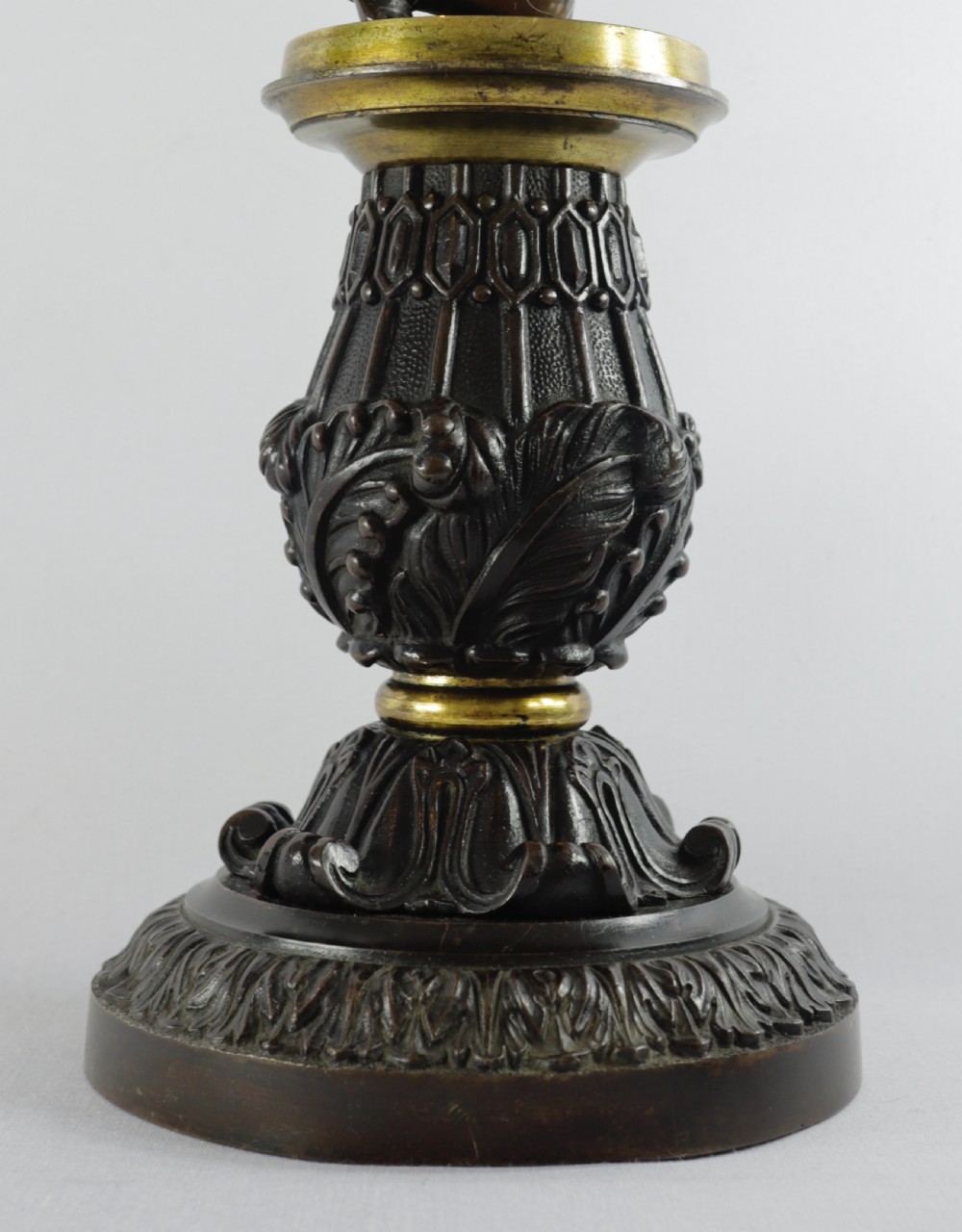 An antique French table lamp base featuring a dark patinated bronze figure of a winged cherub atop an ornate cast pedestal with gilded accents. View VII