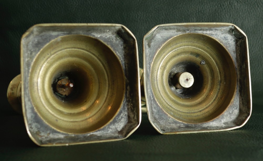 A pair of turned brass candlesticks featuring vase-shaped columns and square stepped bases. View II