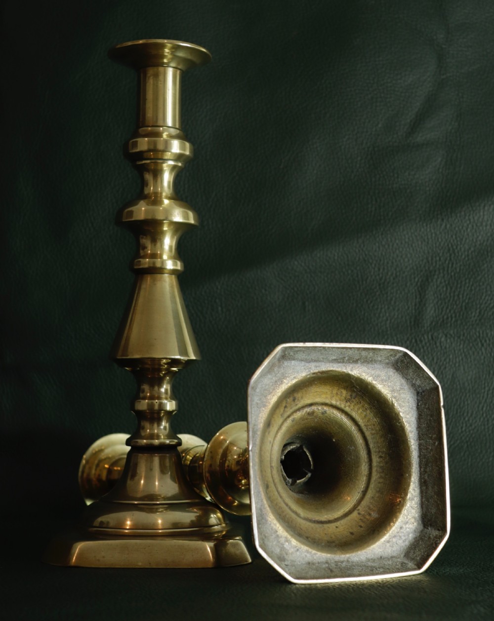 A pair of turned antique brass candlesticks featuring knopped stems and stepped octagonal bases. View II