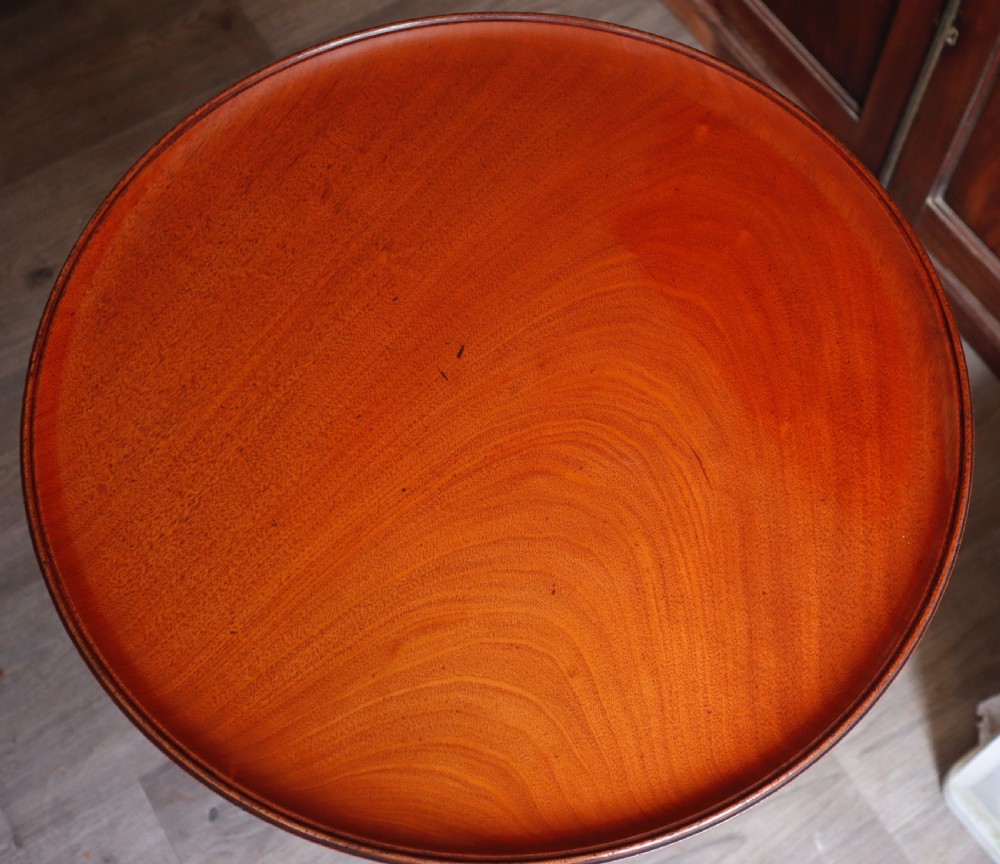 A polished mahogany tripod table with a circular top, turned central column, and three curved legs. View III