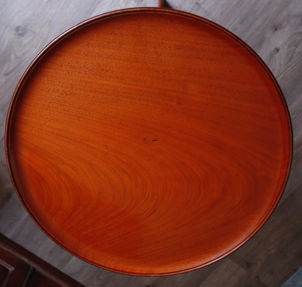 A polished mahogany tripod table with a circular top, turned central column, and three curved legs. View V