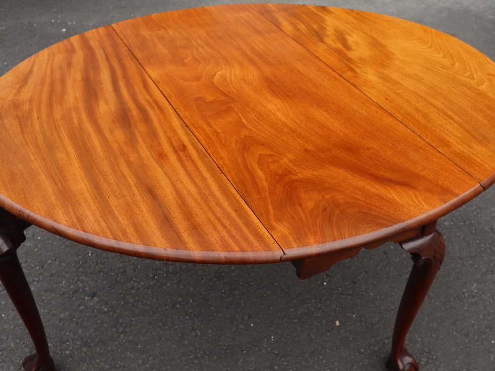 An antique mahogany drop-leaf dining table featuring carved cabriole legs terminating in claw and ball feet. View V