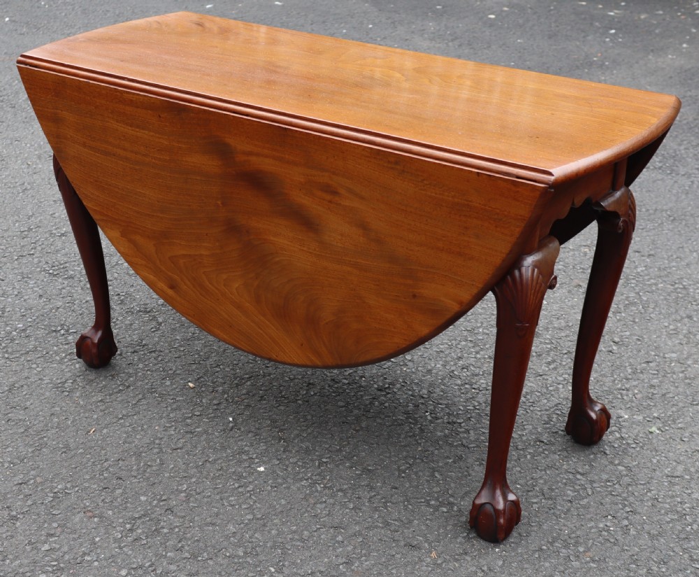 An antique mahogany drop-leaf dining table featuring carved cabriole legs terminating in claw and ball feet. View VII