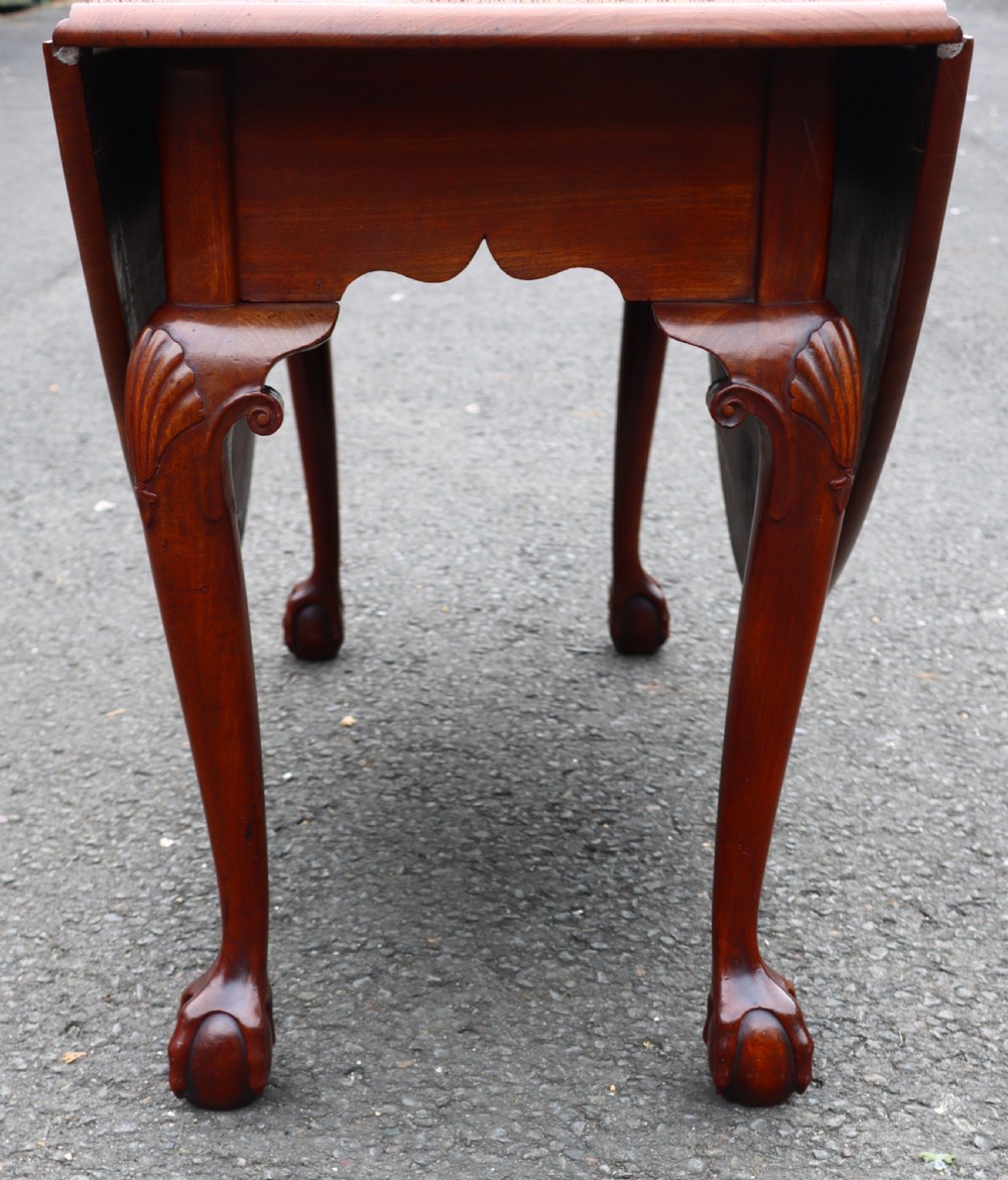 An antique mahogany drop-leaf dining table featuring carved cabriole legs terminating in claw and ball feet. View VIII
