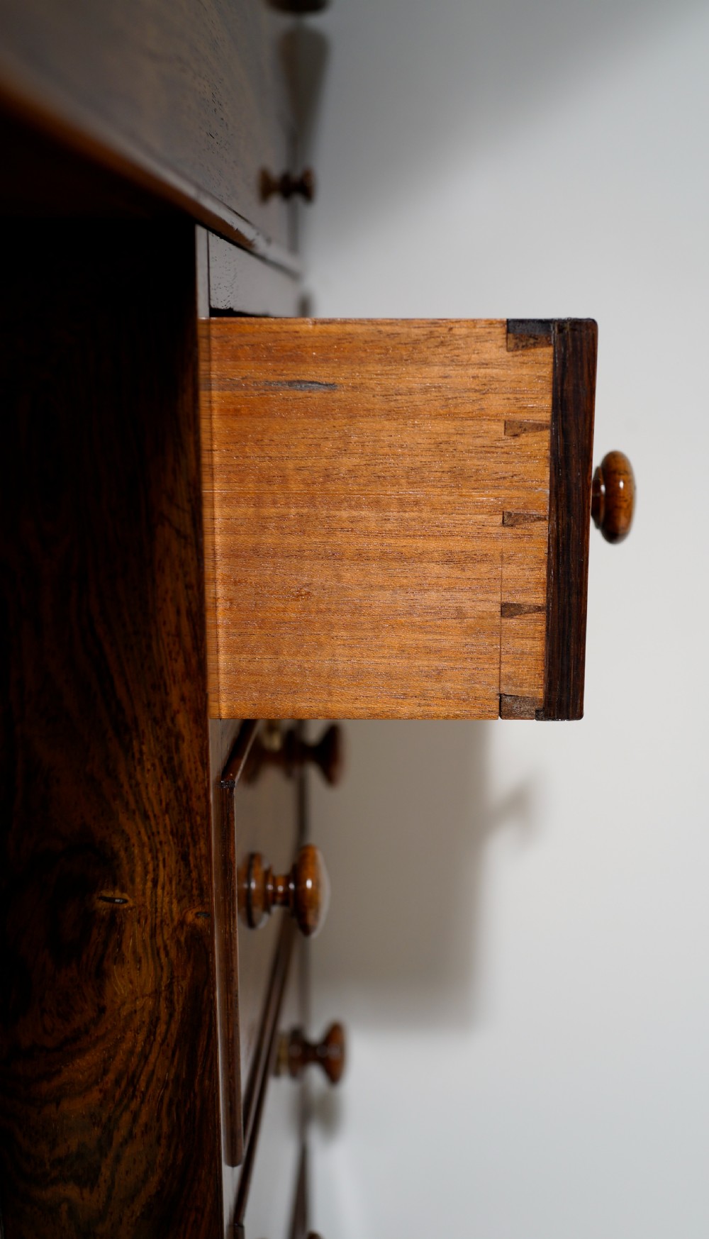 An antique Victorian rosewood Davenport desk featuring a slanted black leather writing surface, a pierced top gallery rail, and turned barley twist front columns. View X