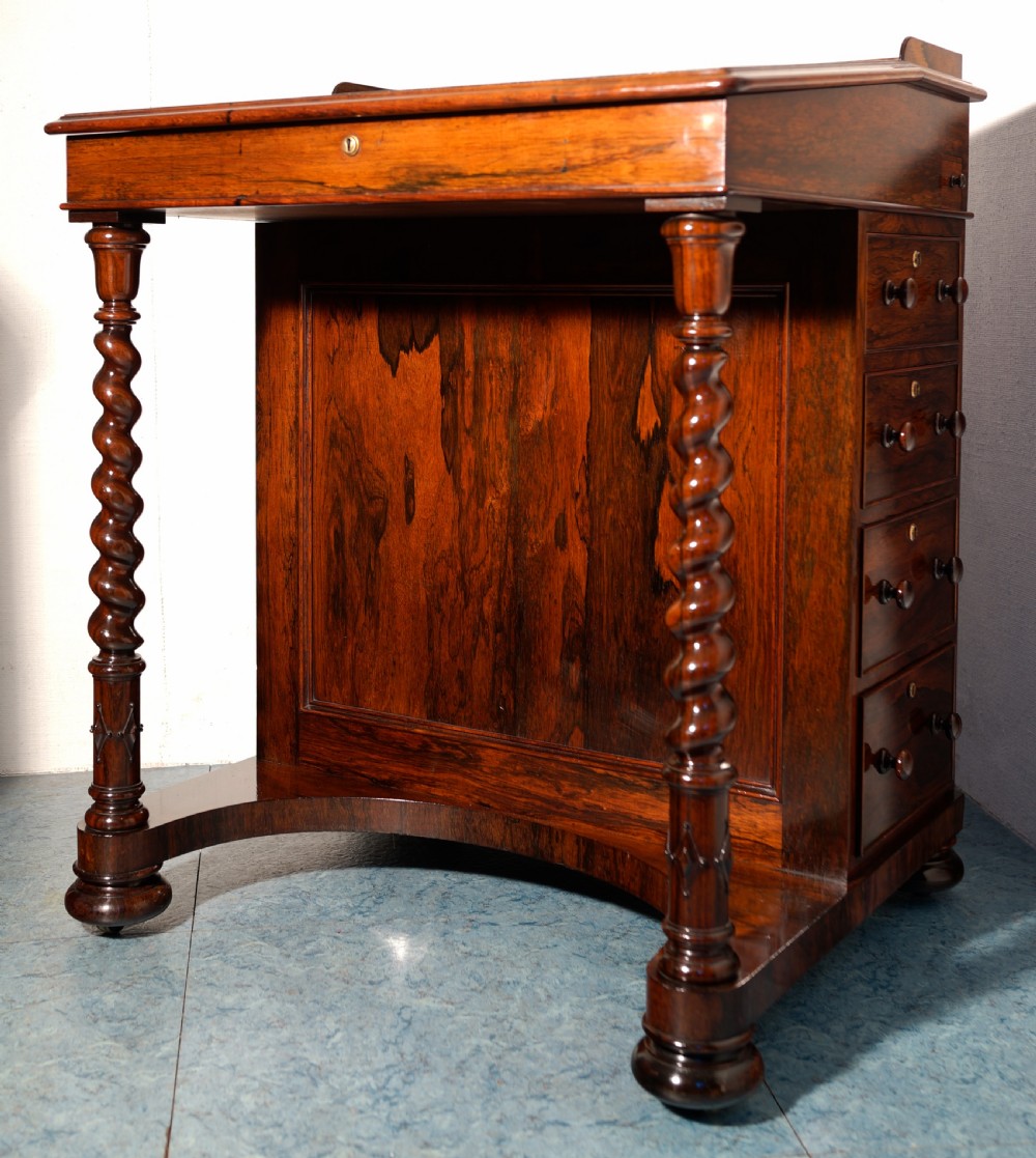 A Victorian dark rosewood Davenport desk featuring spiral turned supports, a sloped writing lid, and a side column of four drawers with turned wooden knobs. View II