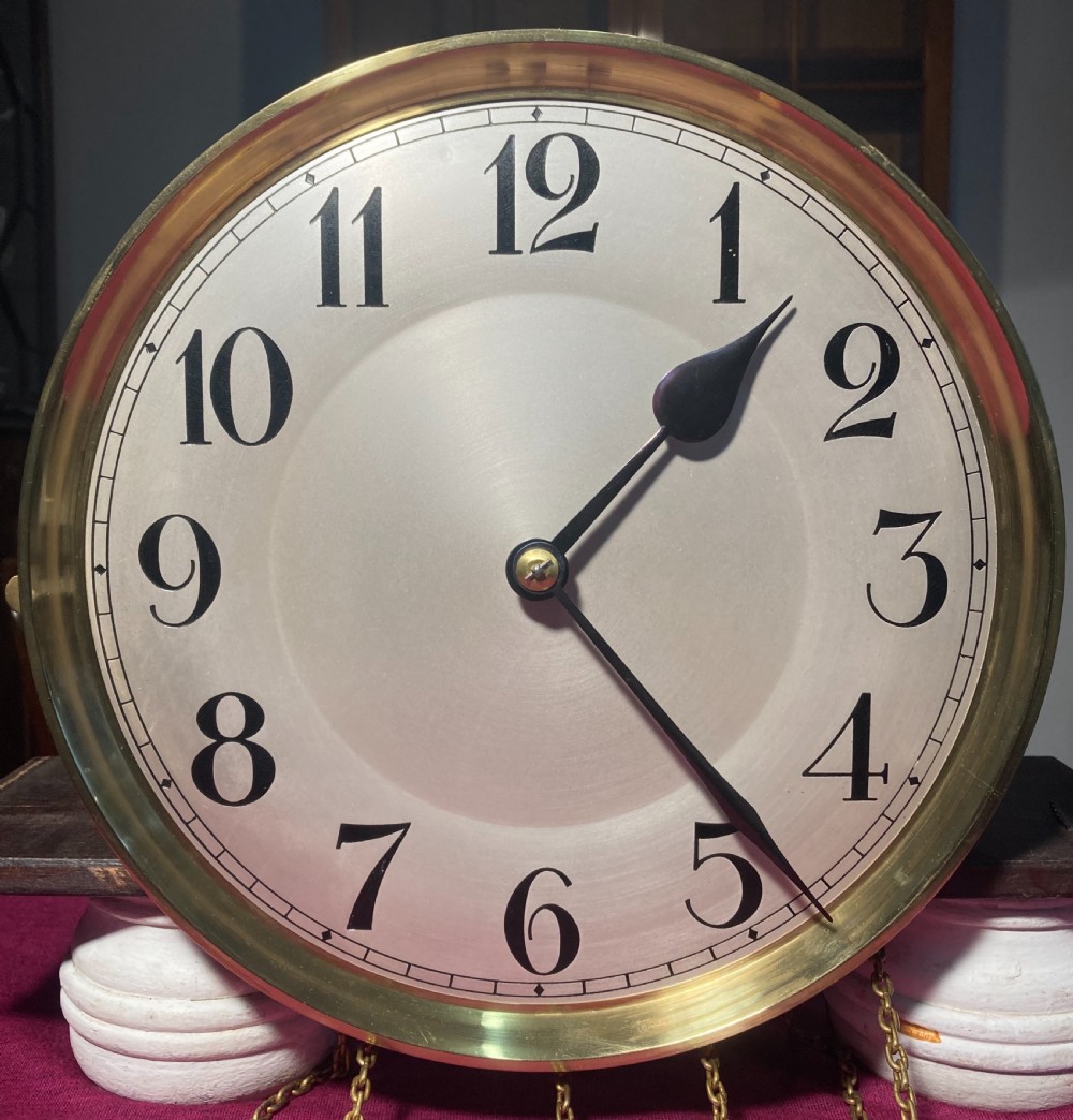 A tall wooden longcase clock featuring fluted corner columns, brass pendulum and weights visible through a glass door, and a circular clock dial with Arabic numerals. View III