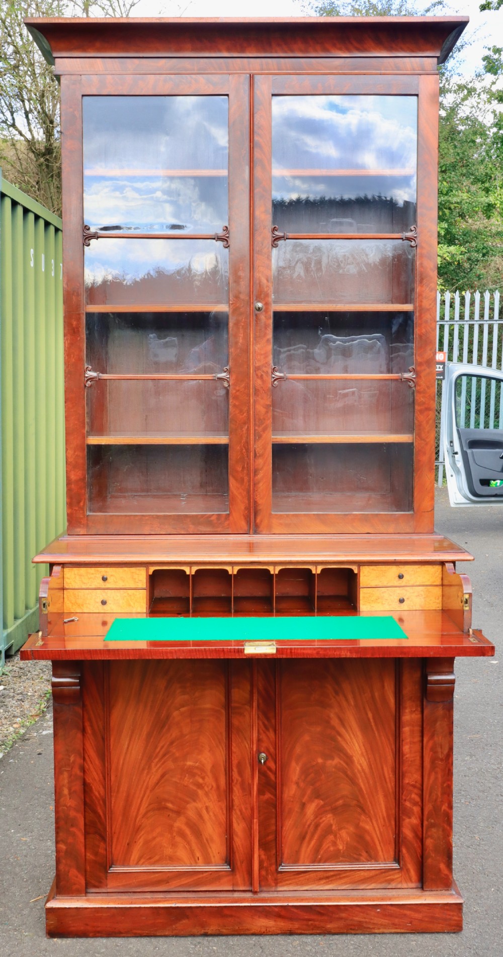 An antique mahogany secretaire bookcase featuring two glazed upper doors, a central writing drawer, and a lower two-door cupboard. View VIII