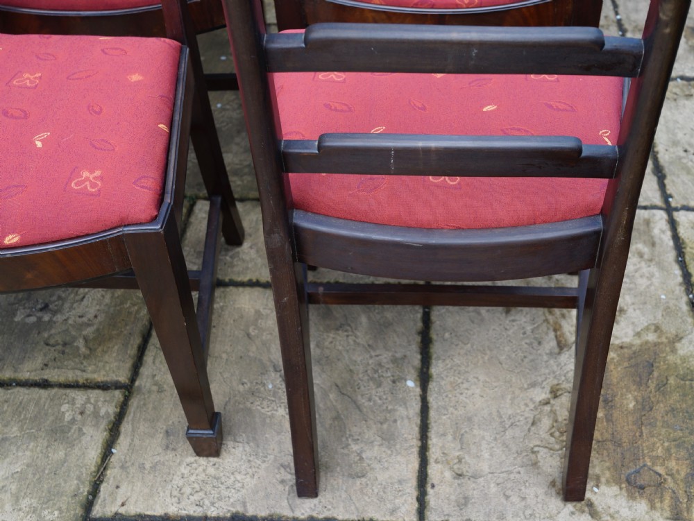 A set of eight mahogany dining chairs featuring arched ladder backs and red patterned fabric upholstered seats. View VIII