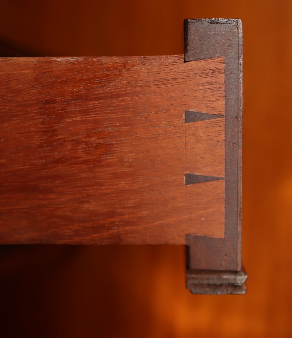 A mahogany pedestal dining table featuring drop-leaf sides, turned central column, four reeded splayed legs, and brass castors. View XIII