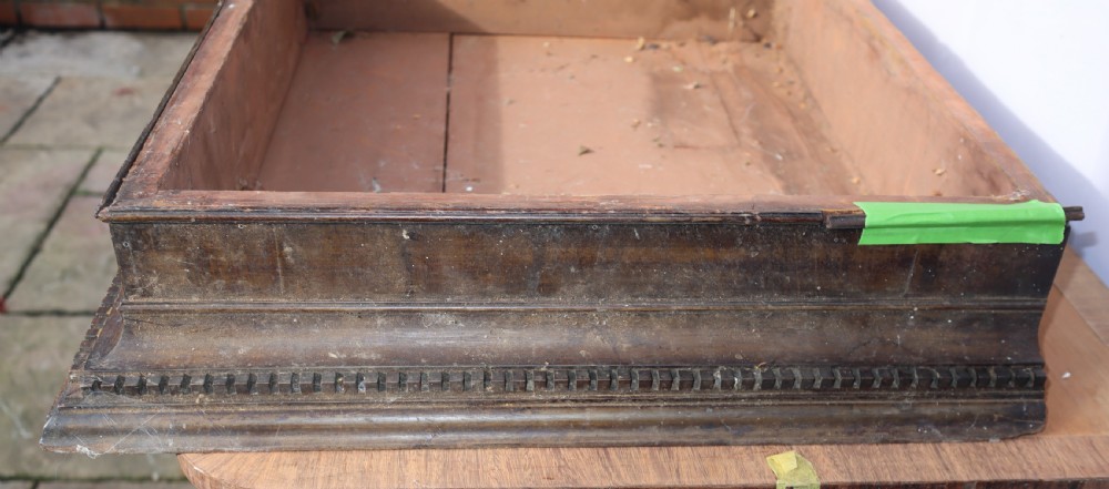 An antique Georgian mahogany cabinet cornice featuring carved dentil moulding and internal timber partition sections. View VI