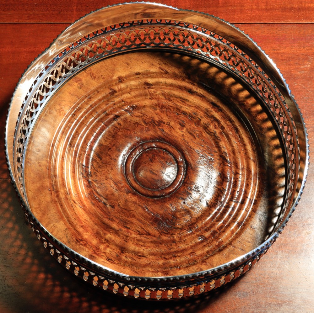A silver-plated bottle coaster featuring a pierced gallery, a scalloped rim with rope-twist edging, and a turned wooden base. View III