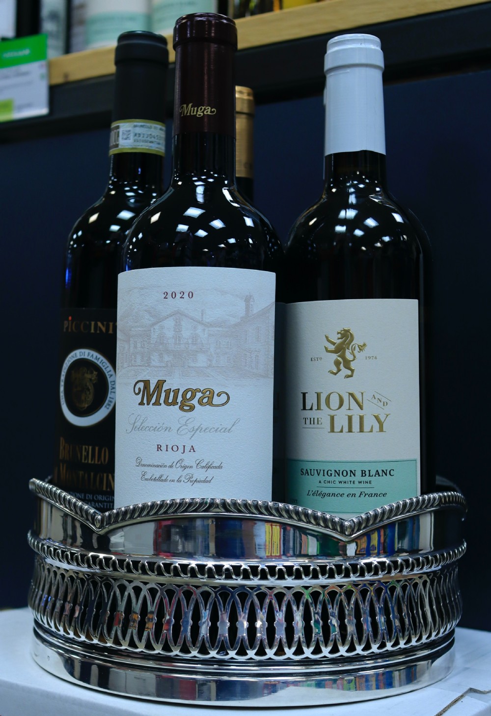 A silver-plated bottle coaster featuring a pierced gallery, a scalloped rim with rope-twist edging, and a turned wooden base. View IV