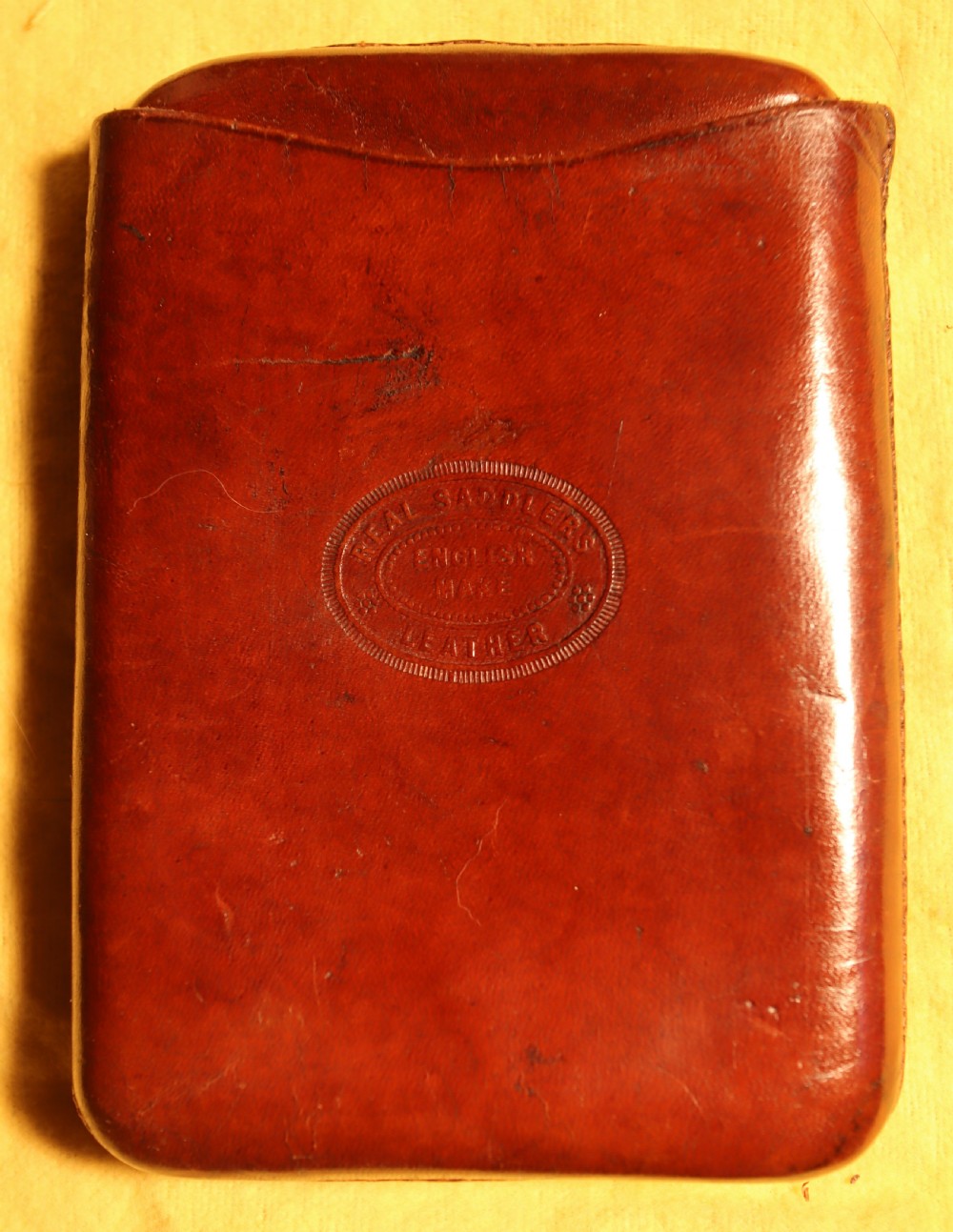 A two-piece chestnut brown saddlers leather cigar case featuring an oval embossed stamp reading Real Saddlers English Make Leather. View II