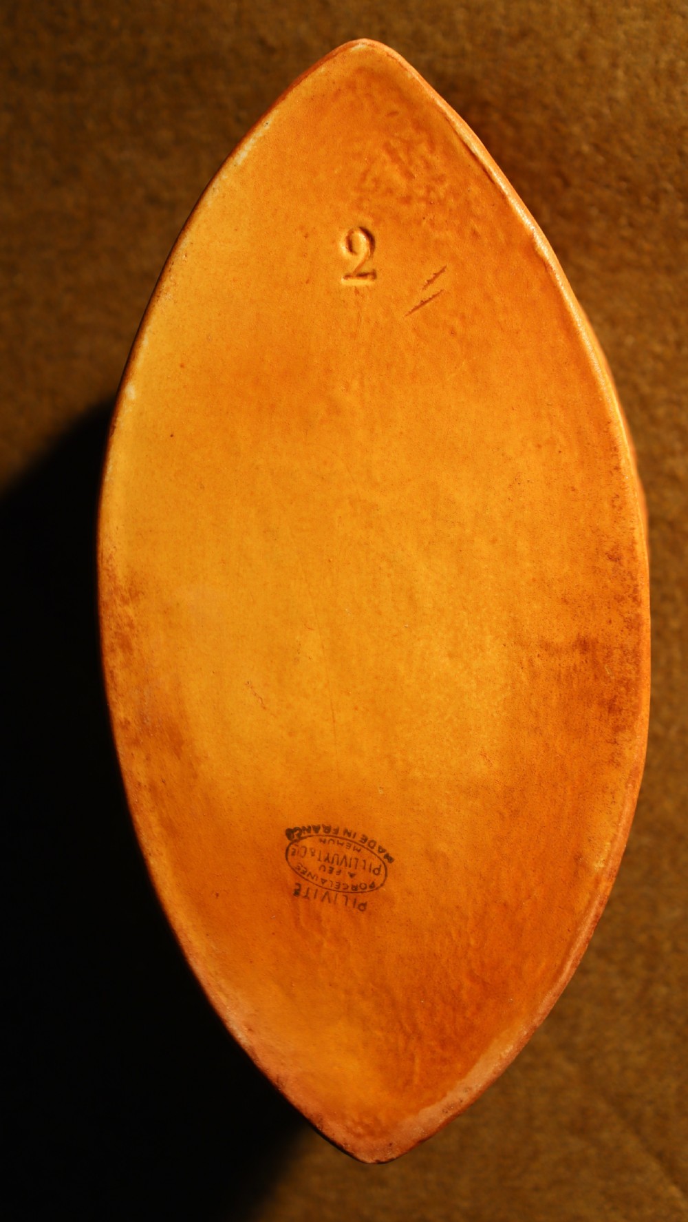 An oval terracotta game pie dish featuring a fluted base and a woven pastry lid topped with a painted bird head finial. View VI