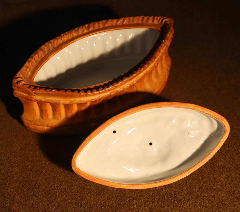 An oval terracotta game pie dish featuring a fluted base and a woven pastry lid topped with a painted bird head finial. View VIII