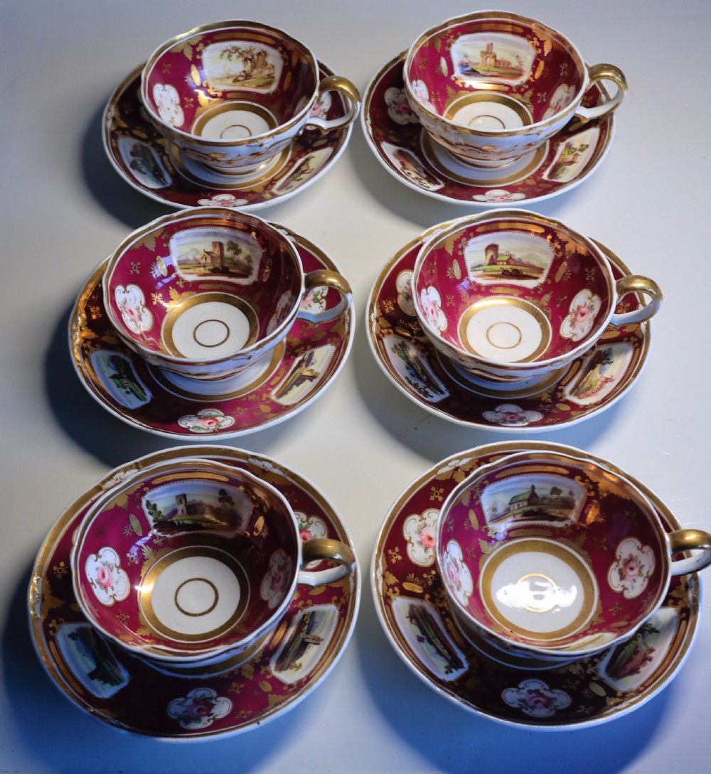 An antique Regency-era Hicks, Meigh & Johnson porcelain tea service featuring crimson ground panels, hand-painted landscape scenes, floral vignettes, and heavy gold leaf gilding. View II