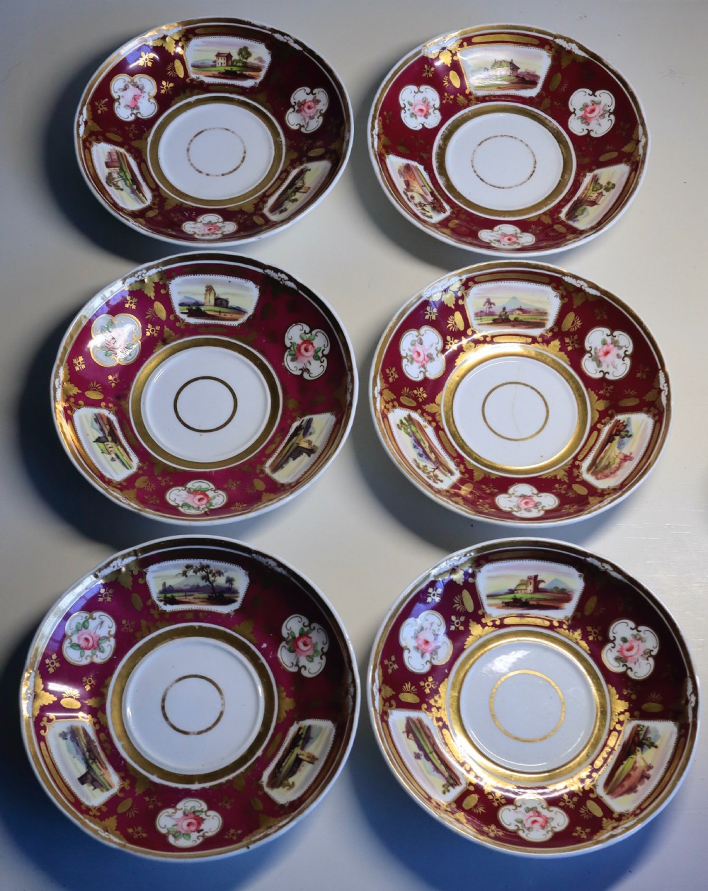 An antique Regency-era Hicks, Meigh & Johnson porcelain tea service featuring crimson ground panels, hand-painted landscape scenes, floral vignettes, and heavy gold leaf gilding. View III