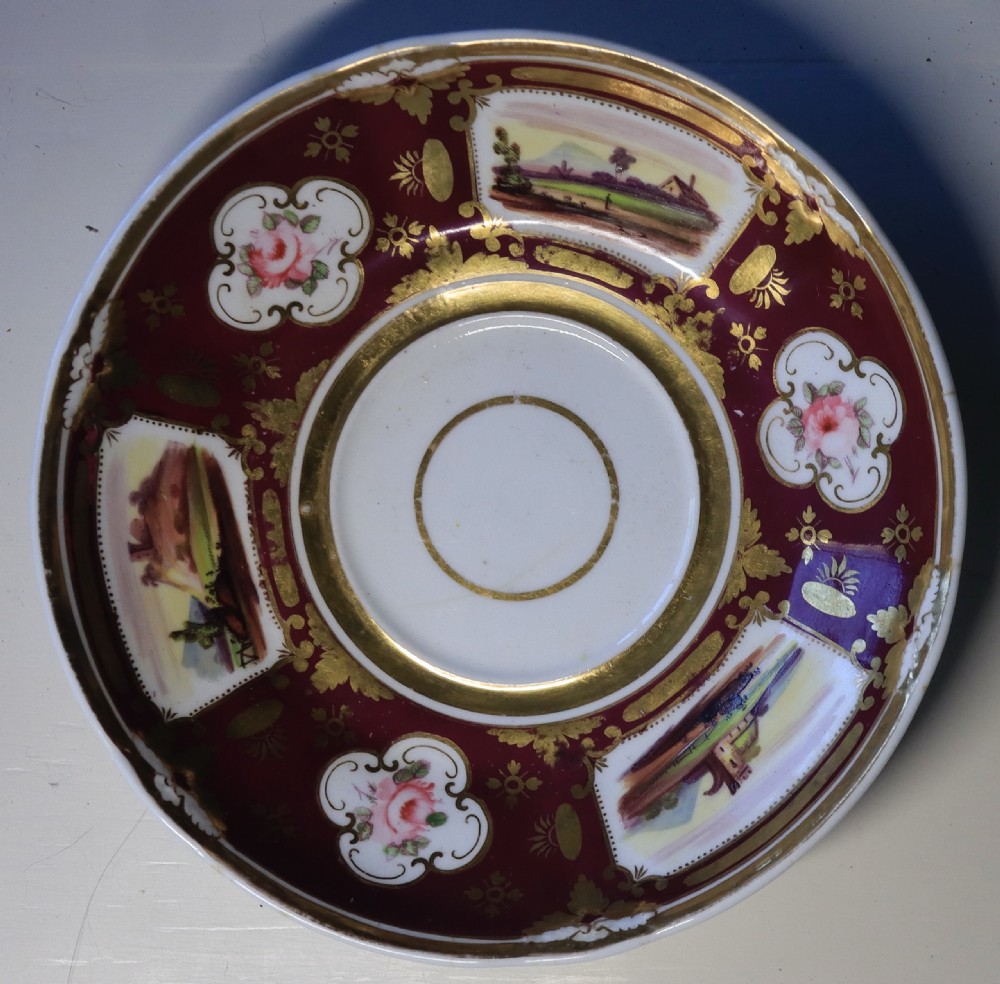 An antique Regency-era Hicks, Meigh & Johnson porcelain tea service featuring crimson ground panels, hand-painted landscape scenes, floral vignettes, and heavy gold leaf gilding. View VII
