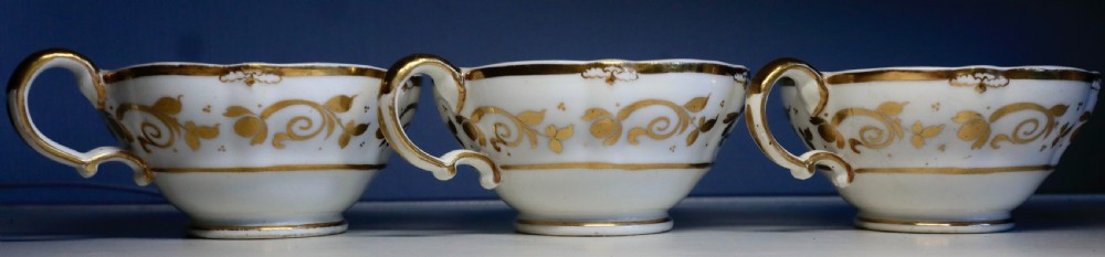 An antique Regency-era Hicks, Meigh & Johnson porcelain tea service featuring crimson ground panels, hand-painted landscape scenes, floral vignettes, and heavy gold leaf gilding. View XI