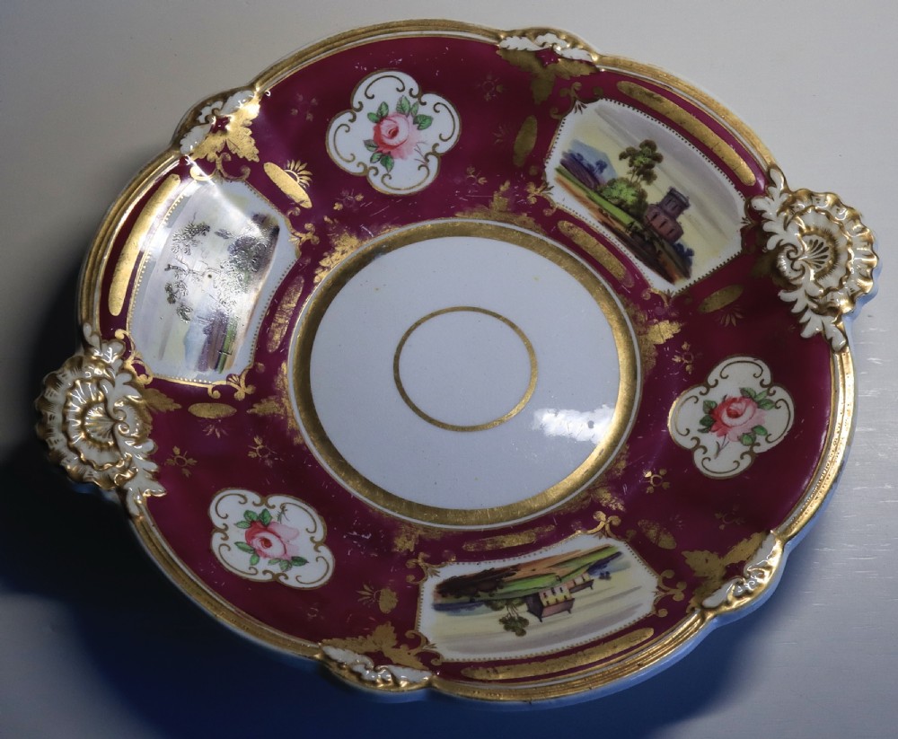 An antique Regency-era Hicks, Meigh & Johnson porcelain tea service featuring crimson ground panels, hand-painted landscape scenes, floral vignettes, and heavy gold leaf gilding. View XIII