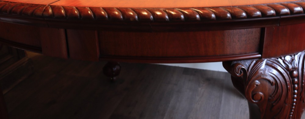 A circular mahogany antique extending dining table featuring carved cabriole legs with ball and claw feet and a rope-carved rim edge. View III