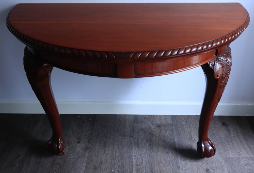 A circular mahogany antique extending dining table featuring carved cabriole legs with ball and claw feet and a rope-carved rim edge. View V