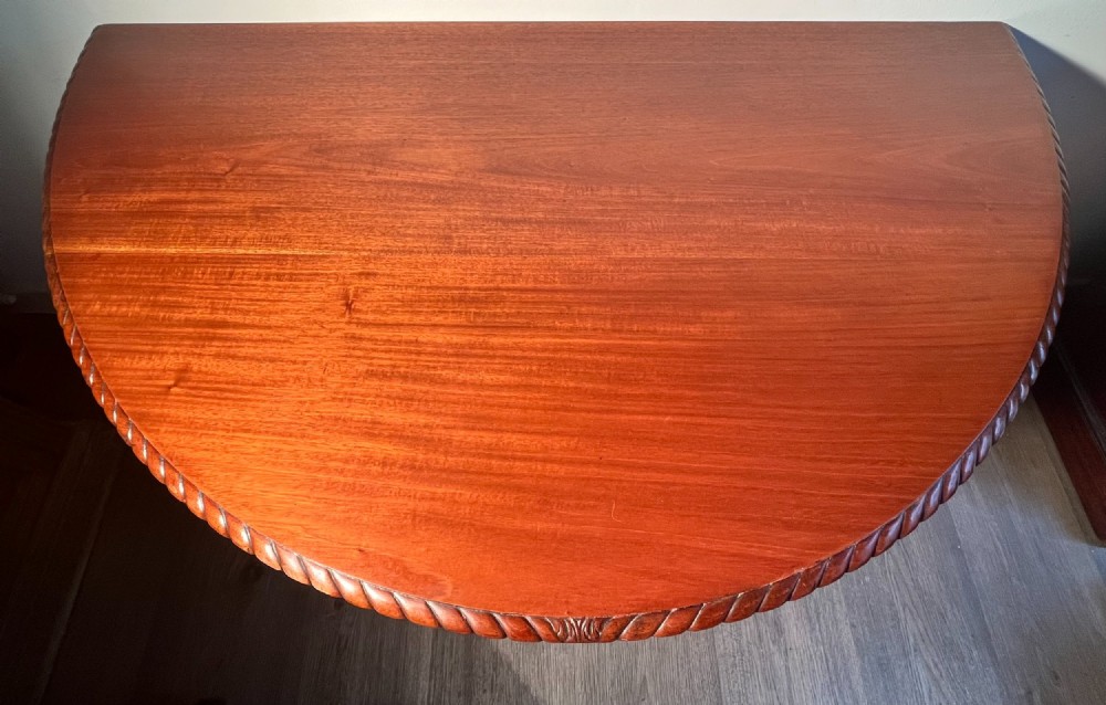 A circular mahogany antique extending dining table featuring carved cabriole legs with ball and claw feet and a rope-carved rim edge. View IX