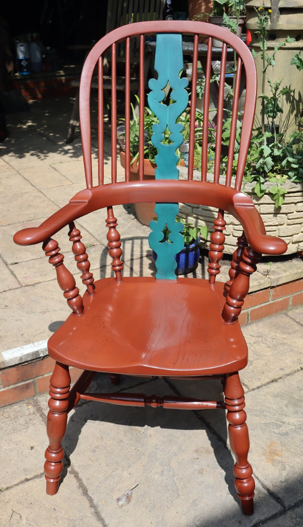 A Victorian hoop-back Windsor armchair painted in terracotta red with a central pierced splat highlighted in teal green. View V