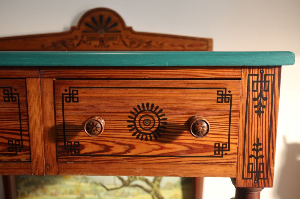 A late Victorian Aesthetic Movement pitch pine side table with a green surface, ebonised geometric incised patterns, two drawers, and turned legs with castors. View IV