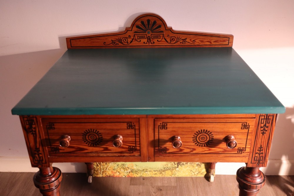 A late Victorian Aesthetic Movement pitch pine side table with a green surface, ebonised geometric incised patterns, two drawers, and turned legs with castors. View V
