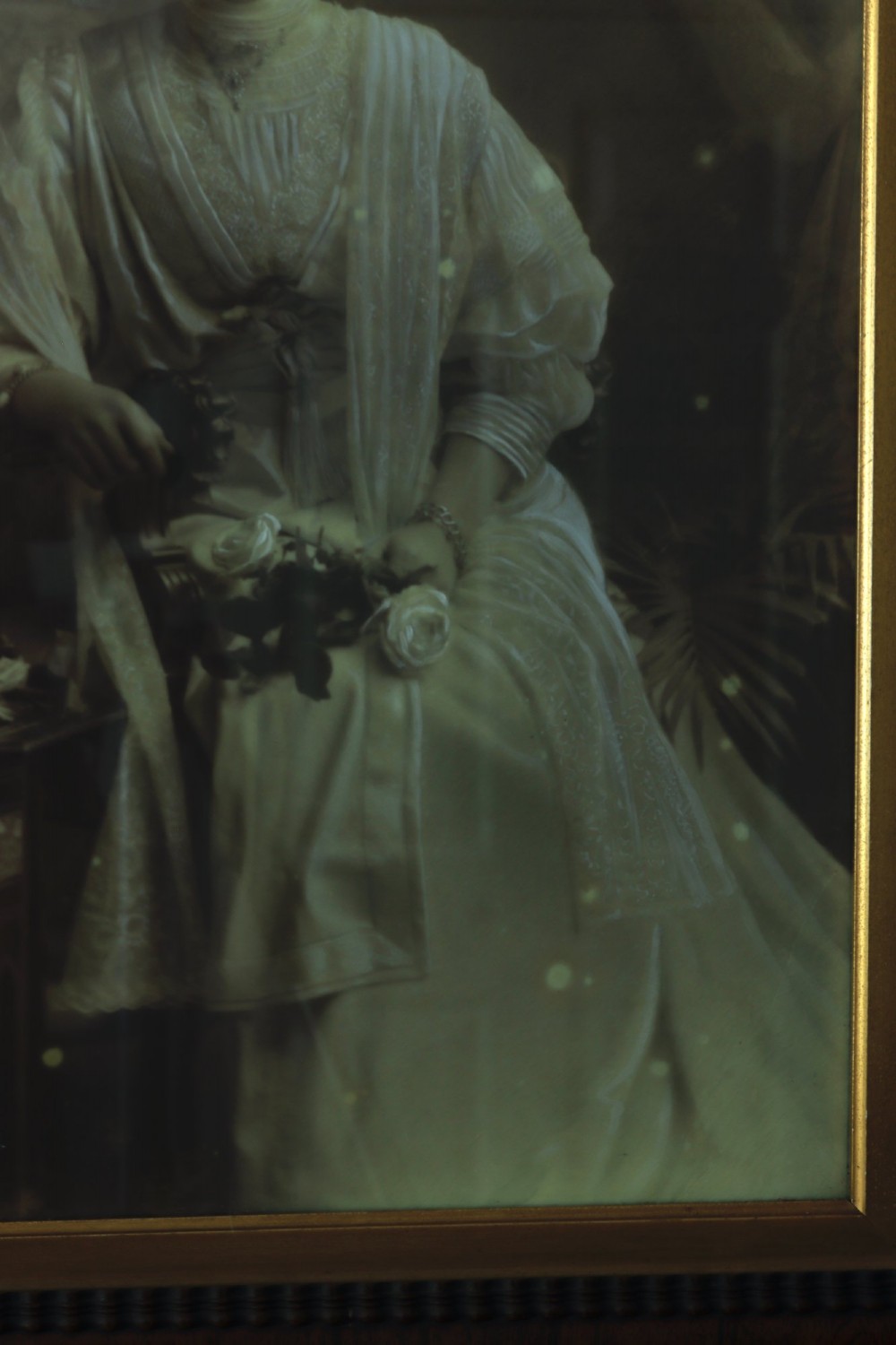 A monochrome Edwardian studio portrait photograph of a seated lady, mounted within a dark polished mahogany frame featuring a gilded inner slip. View IV