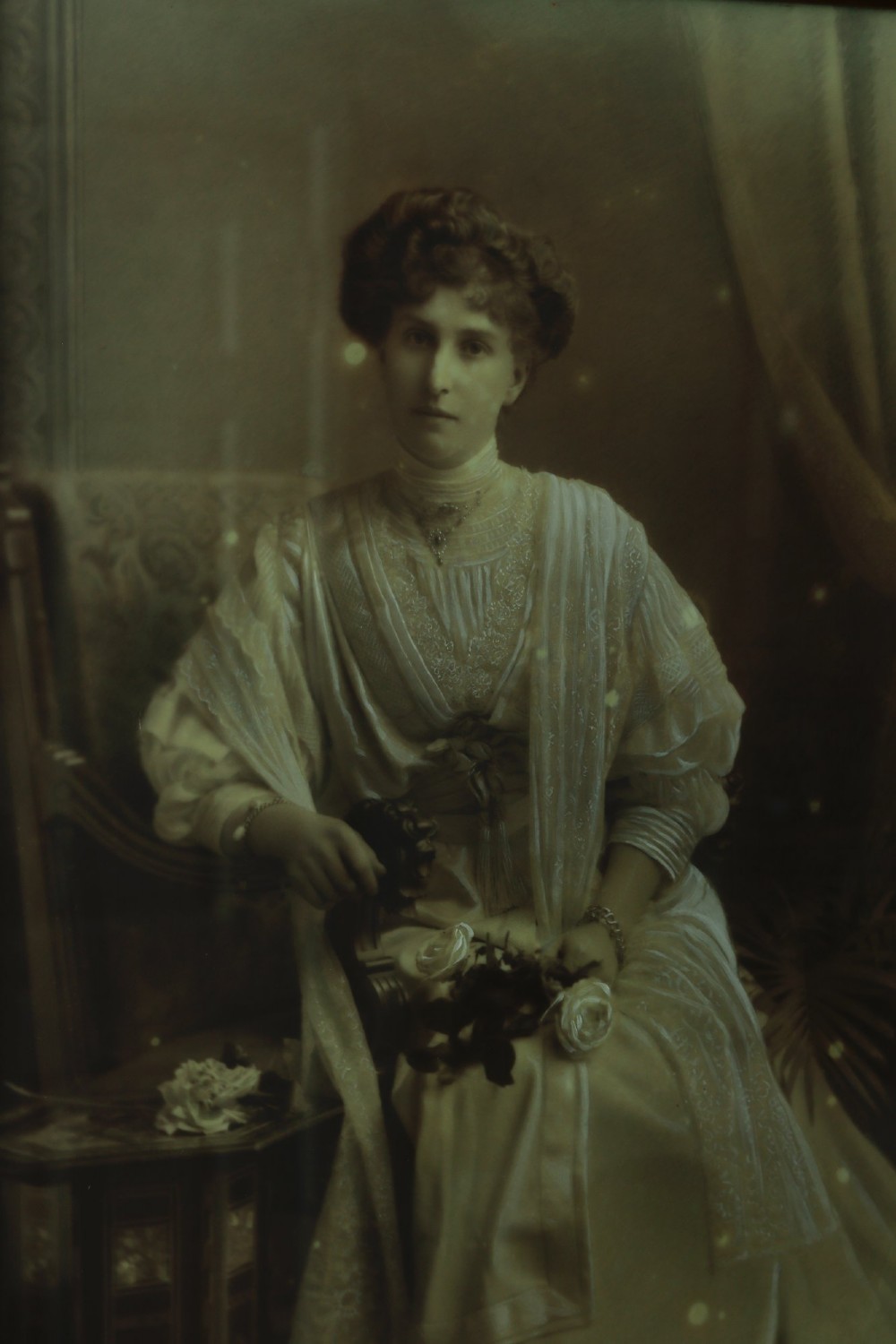 A monochrome Edwardian studio portrait photograph of a seated lady, mounted within a dark polished mahogany frame featuring a gilded inner slip. View V