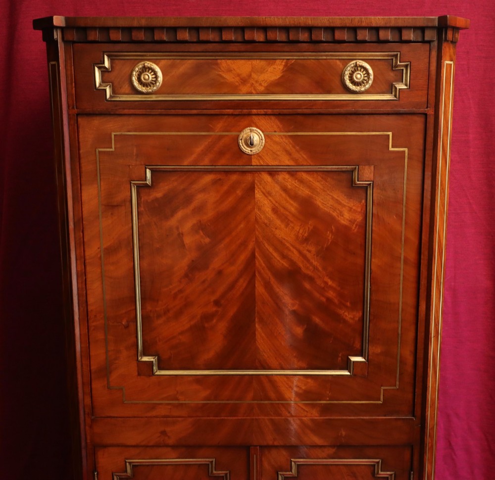 An antique mahogany escritoire featuring brass string inlay, a top drawer, a fall-front writing panel, and a two-door lower cupboard raised on tapered legs. View V
