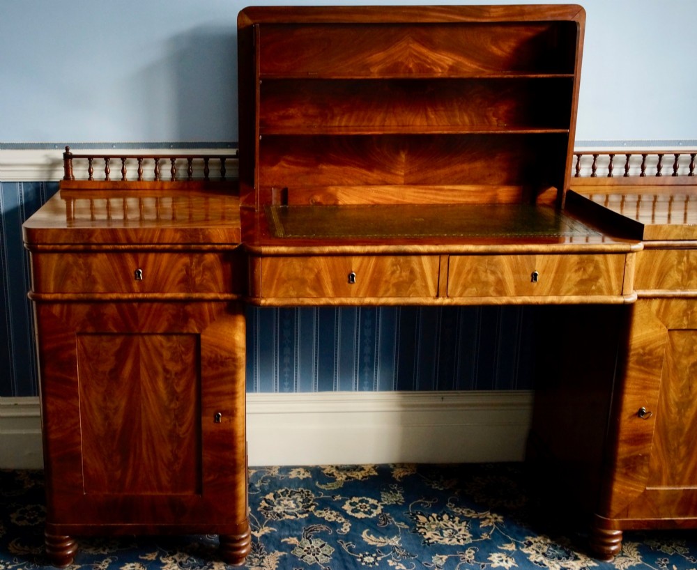 A 19th-century flame mahogany pedestal sideboard featuring a breakfront central section, twin cupboard doors, drawers, and a spindle gallery back rail with carved cresting. View II