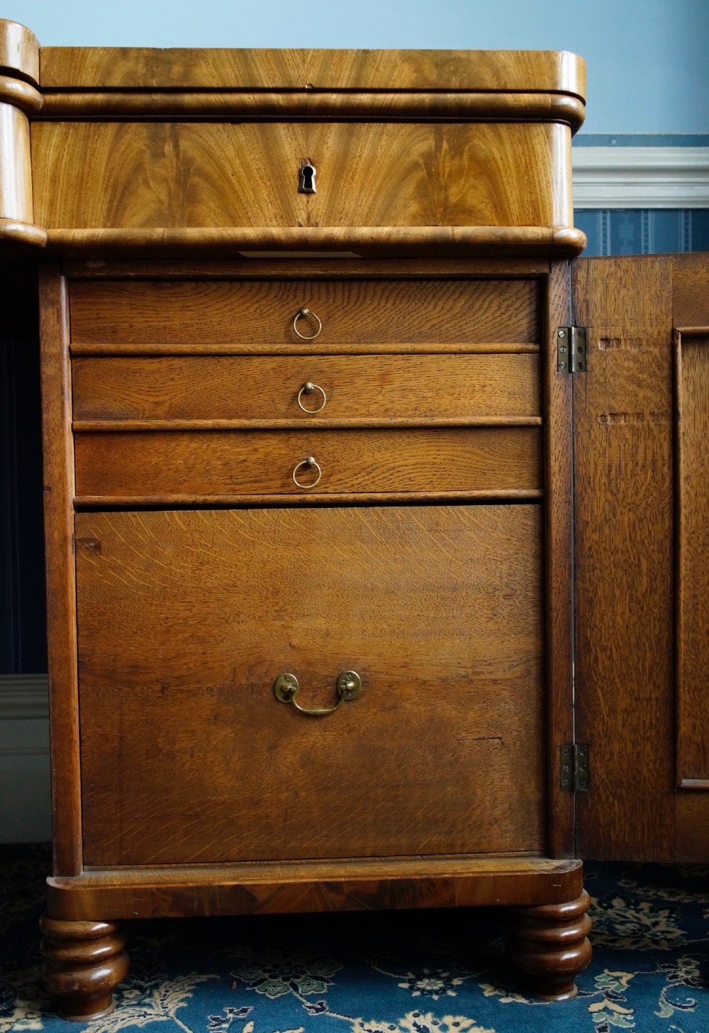 A 19th-century flame mahogany pedestal sideboard featuring a breakfront central section, twin cupboard doors, drawers, and a spindle gallery back rail with carved cresting. View III