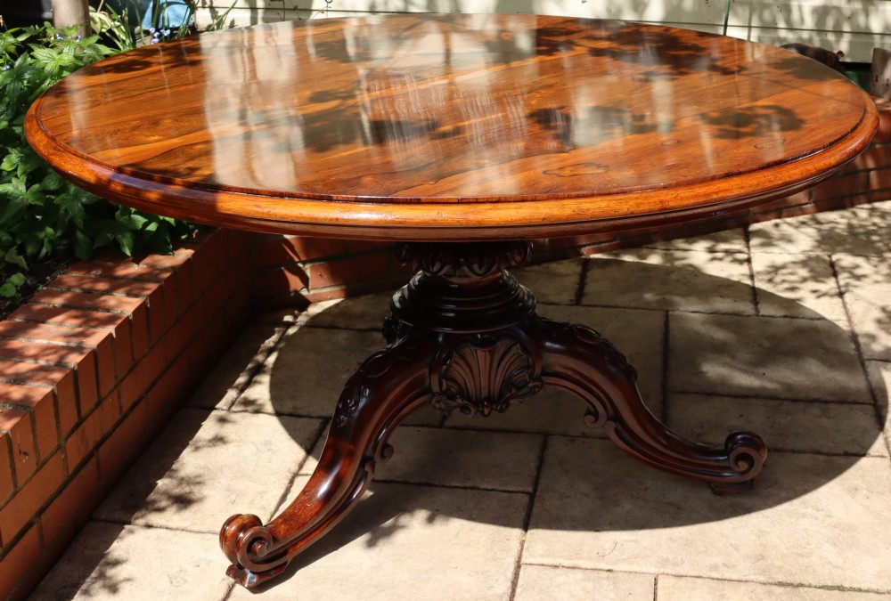 A circular rosewood dining table top exhibiting prominent book-matched grain patterns in shades of warm brown and deep dark brown. View II