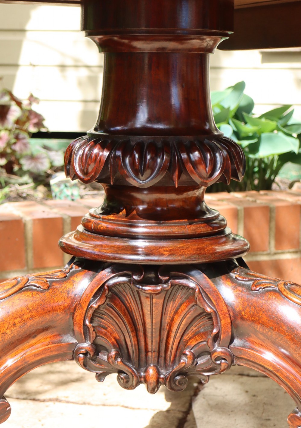 A circular rosewood dining table top exhibiting prominent book-matched grain patterns in shades of warm brown and deep dark brown. View IV