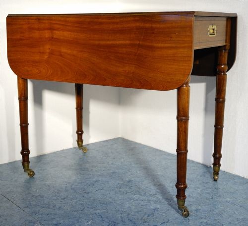 A mahogany Pembroke table featuring two drop leaves, a single frieze drawer with a recessed brass handle, and four turned legs. View II