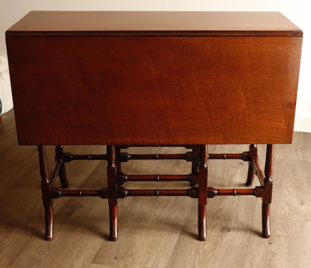 A Georgian mahogany spider leg tea table featuring two hinged drop leaves and slender turned gateleg supports connected by stretchers.