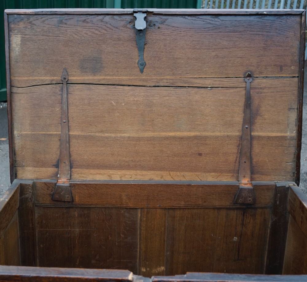 An antique dark oak mule chest featuring geometric fielded panels, turned split-baluster mouldings, lower drawers, and bun feet. View III
