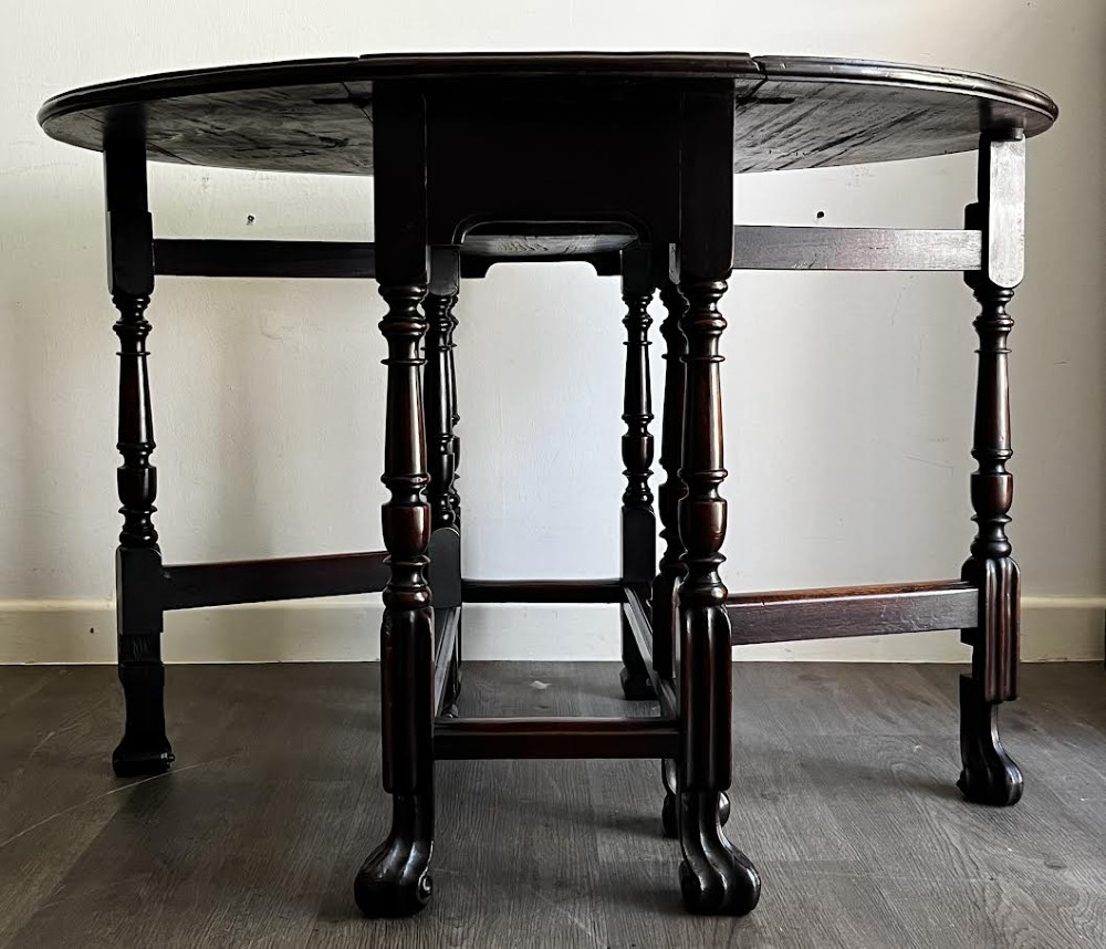 A dark mahogany Georgian drop flap dining table with turned gatelegs and feet. View II