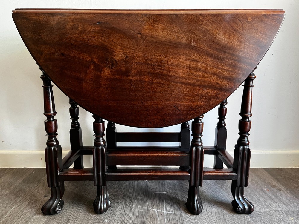 A dark mahogany Georgian drop flap dining table with turned gatelegs and feet. View VI